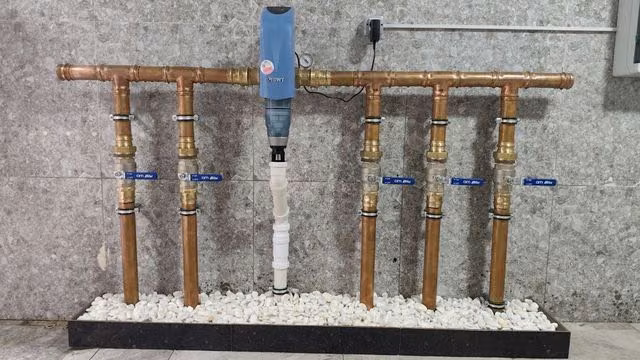Медная гребёнка водопровода с самопромывным фильтром на подиуме с галькой
